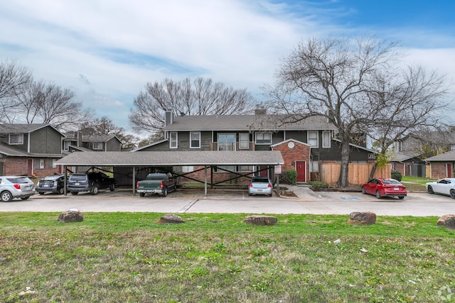 view of front of house featuring a carport and a front lawn