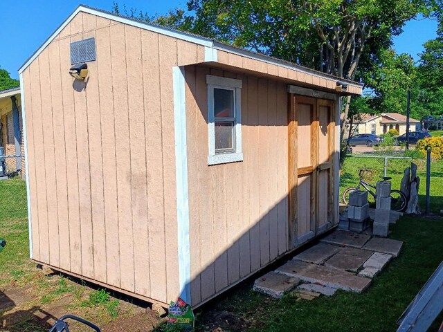 view of outbuilding featuring an outdoor structure and fence