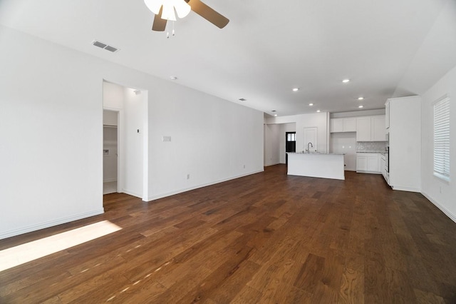 unfurnished living room featuring dark hardwood / wood-style flooring, sink, and ceiling fan