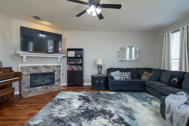 living room with ceiling fan, dark hardwood / wood-style flooring, and a fireplace