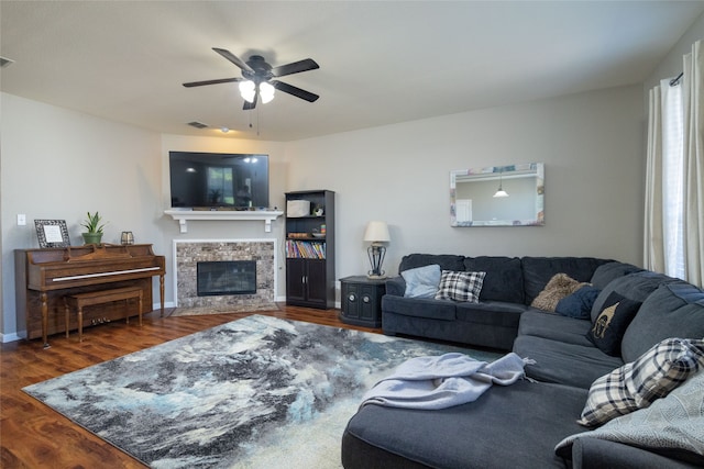 living room featuring ceiling fan, dark hardwood / wood-style flooring, and a fireplace