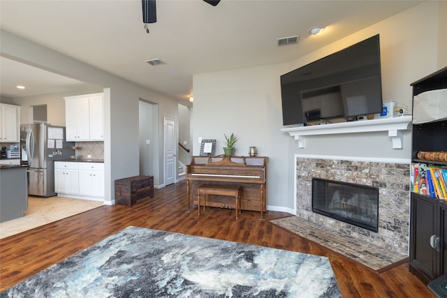 living room featuring ceiling fan and dark hardwood / wood-style floors