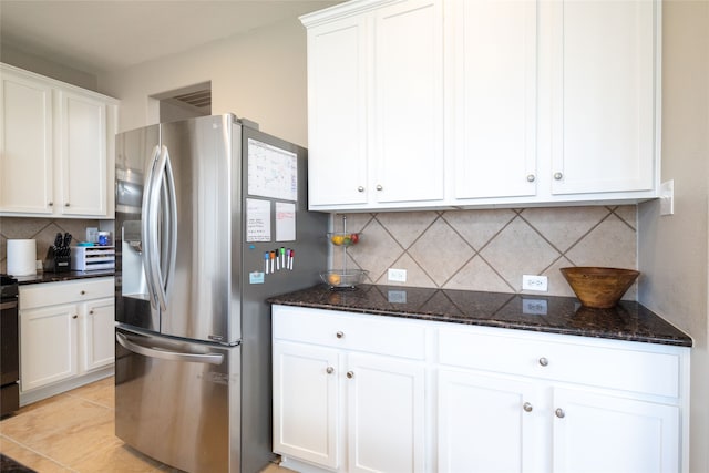 kitchen with decorative backsplash, stainless steel fridge, and white cabinetry