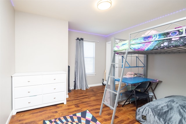 bedroom with dark hardwood / wood-style flooring