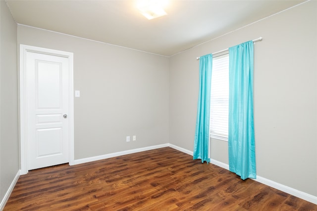 unfurnished room with dark hardwood / wood-style flooring