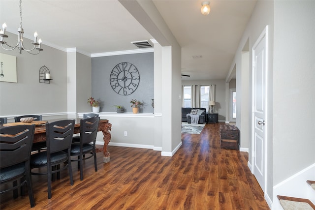 dining room with dark hardwood / wood-style floors, ornamental molding, and a notable chandelier