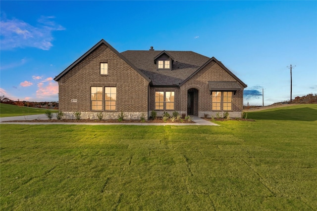 french country inspired facade featuring a front yard