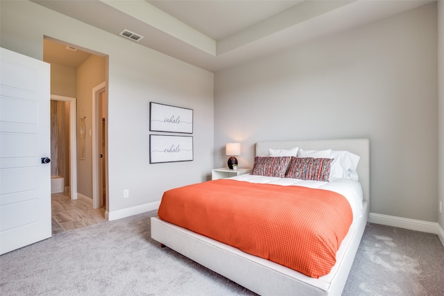 bedroom with ensuite bath and carpet