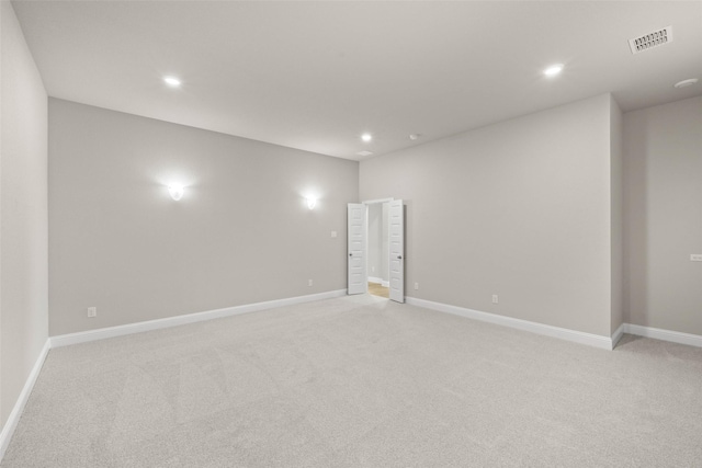 spare room featuring light carpet, visible vents, and recessed lighting