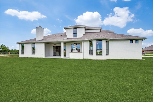 back of property featuring ceiling fan, a lawn, and a patio area