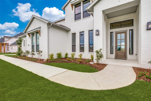 view of exterior entry featuring a yard