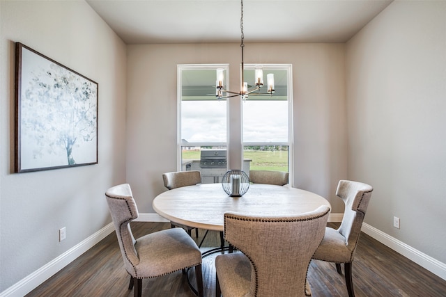 dining room with dark wood-type flooring and a chandelier