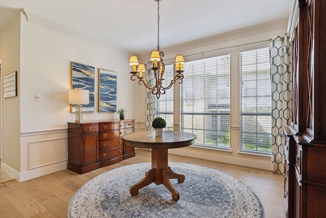 dining area featuring ornamental molding, plenty of natural light, a chandelier, and light hardwood / wood-style floors