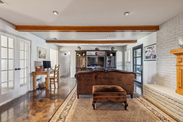 living room featuring beamed ceiling, french doors, brick wall, a brick fireplace, and concrete flooring