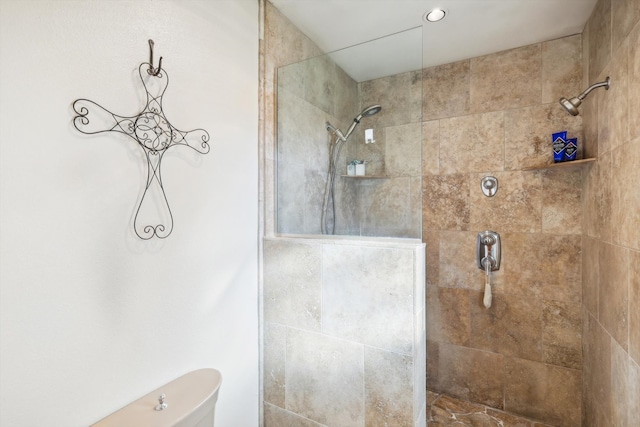 bathroom with tiled shower and toilet