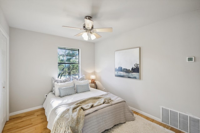 bedroom featuring light hardwood / wood-style floors, ceiling fan, and a closet