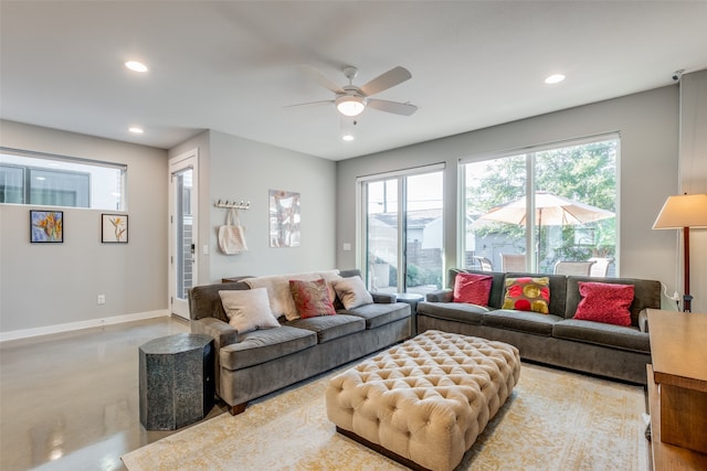 living room featuring ceiling fan and concrete flooring