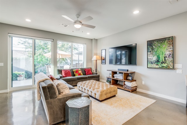 living room featuring concrete flooring, plenty of natural light, and ceiling fan