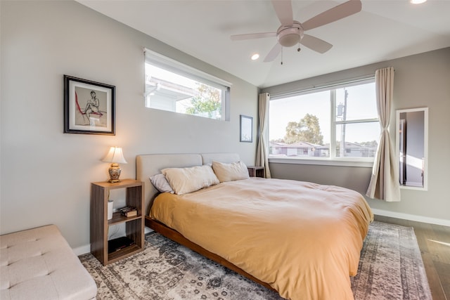 bedroom featuring multiple windows, vaulted ceiling, ceiling fan, and hardwood / wood-style flooring