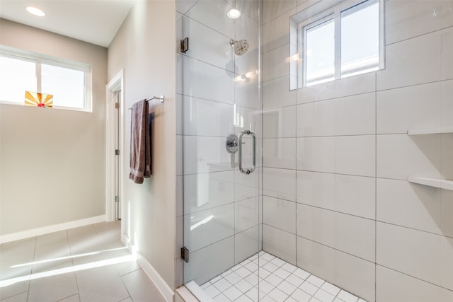 bathroom with a shower with shower door and tile patterned flooring