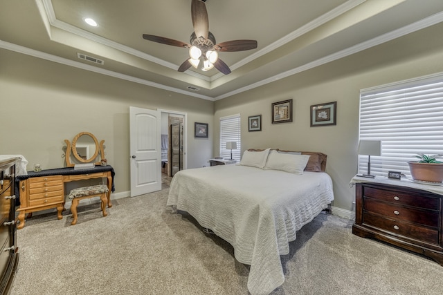 carpeted bedroom featuring ornamental molding, a tray ceiling, and ceiling fan