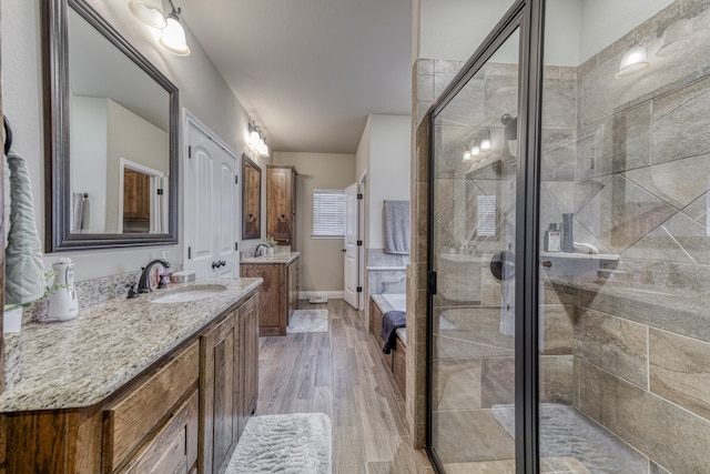 bathroom with hardwood / wood-style floors, a shower with door, and vanity