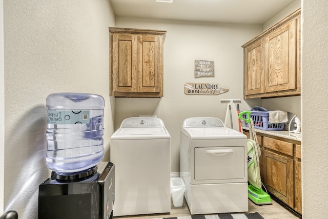 washroom featuring cabinets, light hardwood / wood-style flooring, and independent washer and dryer