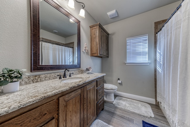 bathroom featuring wood-type flooring, vanity, toilet, and a shower with shower curtain