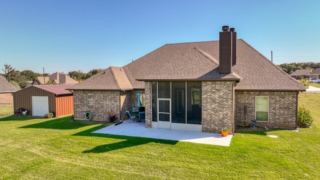 rear view of house with a garage, a patio area, and a yard