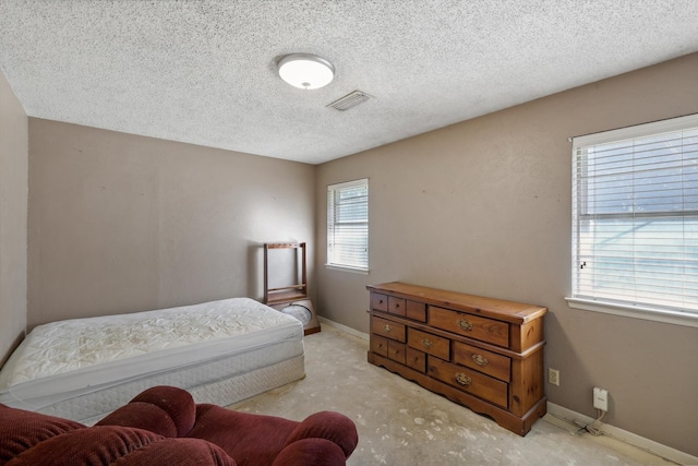 bedroom featuring a textured ceiling and multiple windows