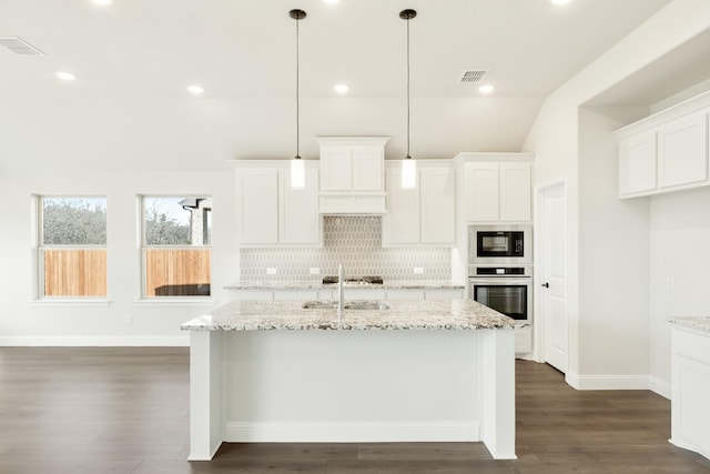 kitchen with sink, white cabinetry, appliances with stainless steel finishes, and a center island with sink