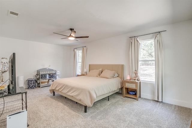 bedroom featuring ceiling fan, carpet floors, and multiple windows