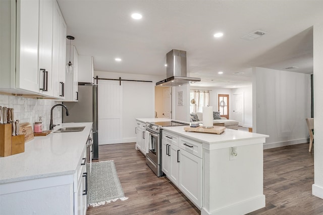 kitchen with ventilation hood, white cabinets, stainless steel electric range oven, a barn door, and dark hardwood / wood-style flooring