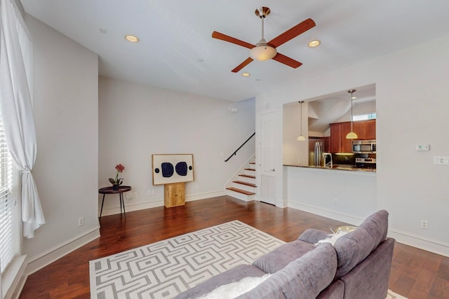 living room featuring ceiling fan and dark hardwood / wood-style floors