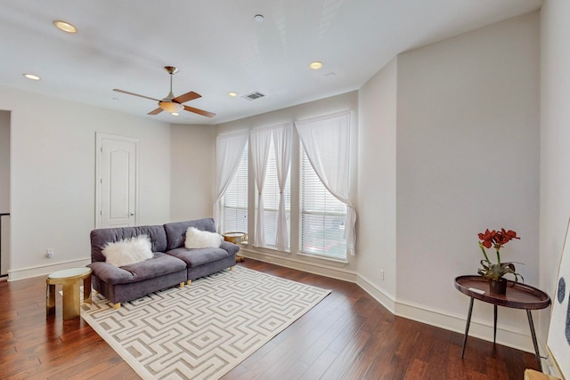 living room with dark wood-type flooring and ceiling fan