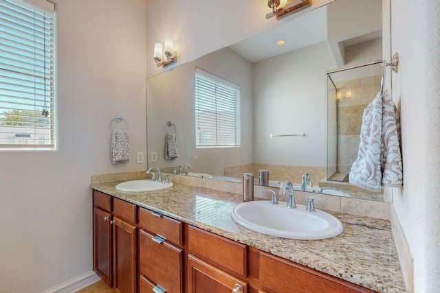 bathroom with a wealth of natural light, vanity, and a shower with door