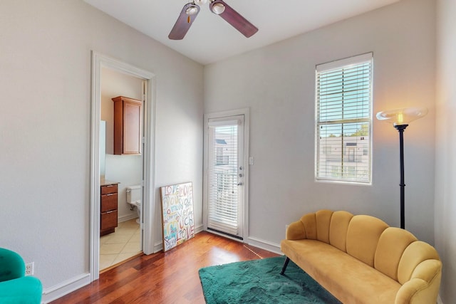 living area featuring hardwood / wood-style flooring, a healthy amount of sunlight, and ceiling fan