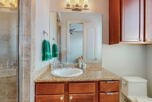 bathroom featuring vanity, toilet, and a shower with door