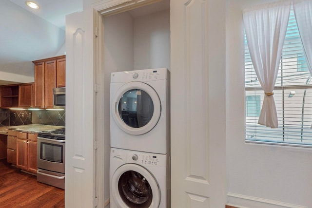 laundry area with dark hardwood / wood-style flooring and stacked washer / dryer