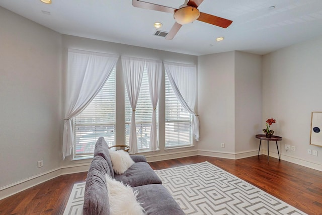 living room featuring dark hardwood / wood-style flooring, ceiling fan, and plenty of natural light