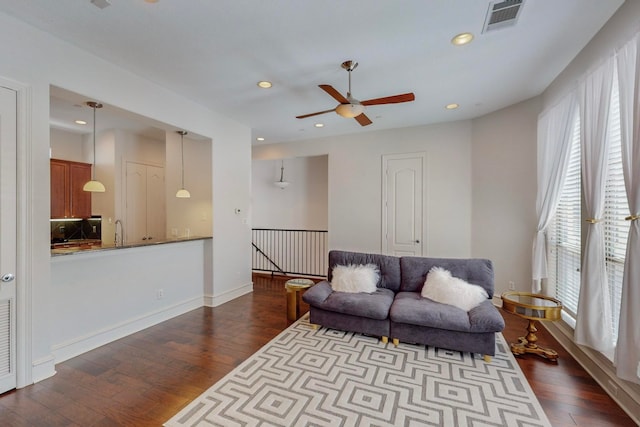 living room with wood-type flooring and ceiling fan