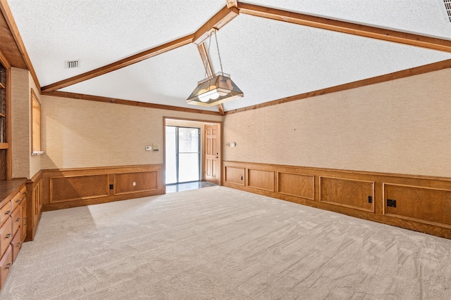 interior space with lofted ceiling with beams and a textured ceiling