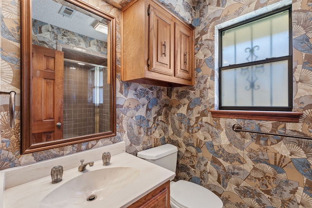 bathroom featuring an enclosed shower, vanity, toilet, and a textured ceiling