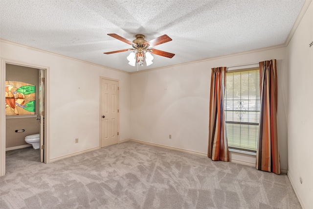 carpeted empty room with a textured ceiling, ceiling fan, and ornamental molding