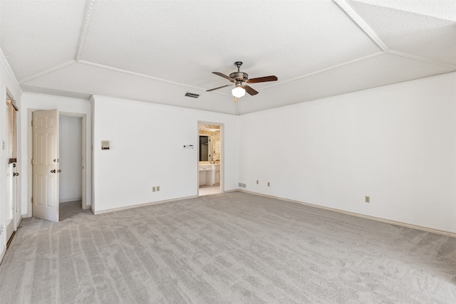 unfurnished bedroom with light carpet, ensuite bath, ceiling fan, and lofted ceiling