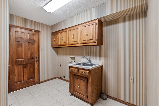 laundry area with sink, cabinets, washer hookup, hookup for an electric dryer, and a textured ceiling