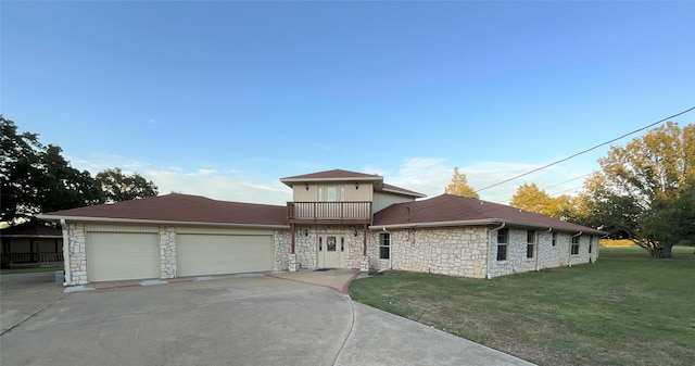 view of front of home featuring driveway, a front lawn, an attached garage, and stone siding