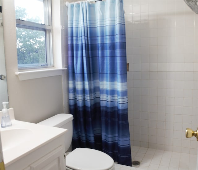 full bathroom with toilet, a tile shower, and vanity