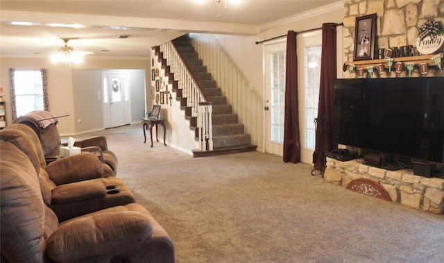 carpeted living area featuring baseboards, ceiling fan, stairway, and crown molding