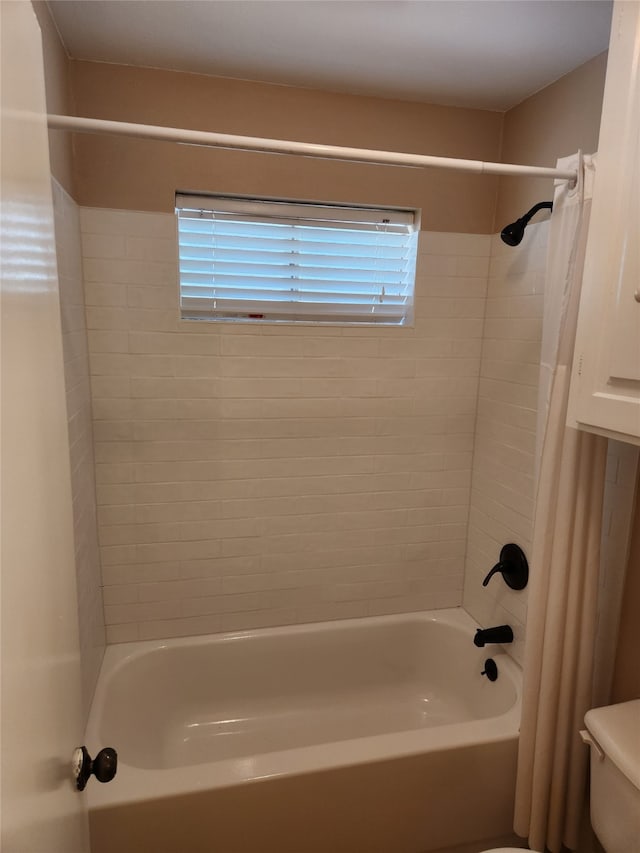 bathroom with toilet and shower / bathtub combination with curtain